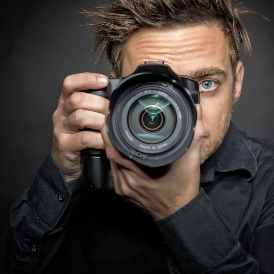 Elegante Hochzeitssaal-Dekoration in einer stilvollen Eventlocation im Schwarzwald. Die runden Tische sind mit weißen Tischdecken, edlem Geschirr und kunstvoll gefalteten Servietten eingedeckt. Stühle mit weißen Hussen und braunen Schleifen verleihen der Location eine festliche Atmosphäre. Perfekte Wahl für Hochzeiten und Feiern in den Locations Schwarzwald.