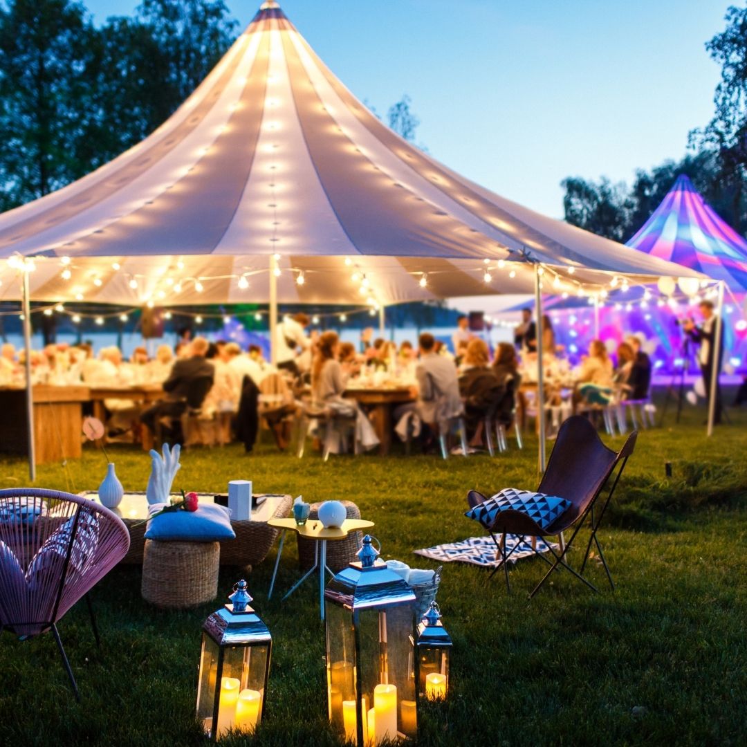 Elegante Hochzeitssaal-Dekoration in einer stilvollen Eventlocation im Schwarzwald. Die runden Tische sind mit weißen Tischdecken, edlem Geschirr und kunstvoll gefalteten Servietten eingedeckt. Stühle mit weißen Hussen und braunen Schleifen verleihen der Location eine festliche Atmosphäre. Perfekte Wahl für Hochzeiten und Feiern in den Locations Schwarzwald.