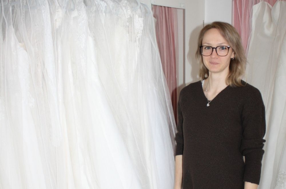 Yes to the Dress in Rheinau Mandy von Yes2theDress neben ihren Brautkleidern.